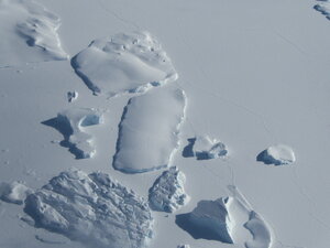 Impressive icebergs locked in the sea ice as we pass overhead.