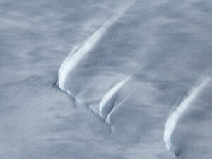 These create windtails as the atmosphere blows snow across those cracks.